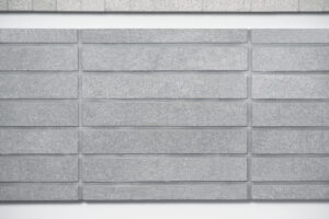 Uniform long rectangular grey tiles with grey mortar.