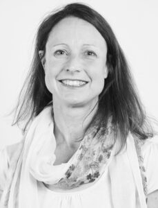 Black and white photo of Christine Hemphill, a smiling white woman with dark, shoulder-length hair.