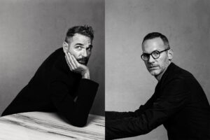 Two black and white headshot images of men; the one on the left rests his head on his hand and looks up and away from camera, the one on the right looks straight to camera.