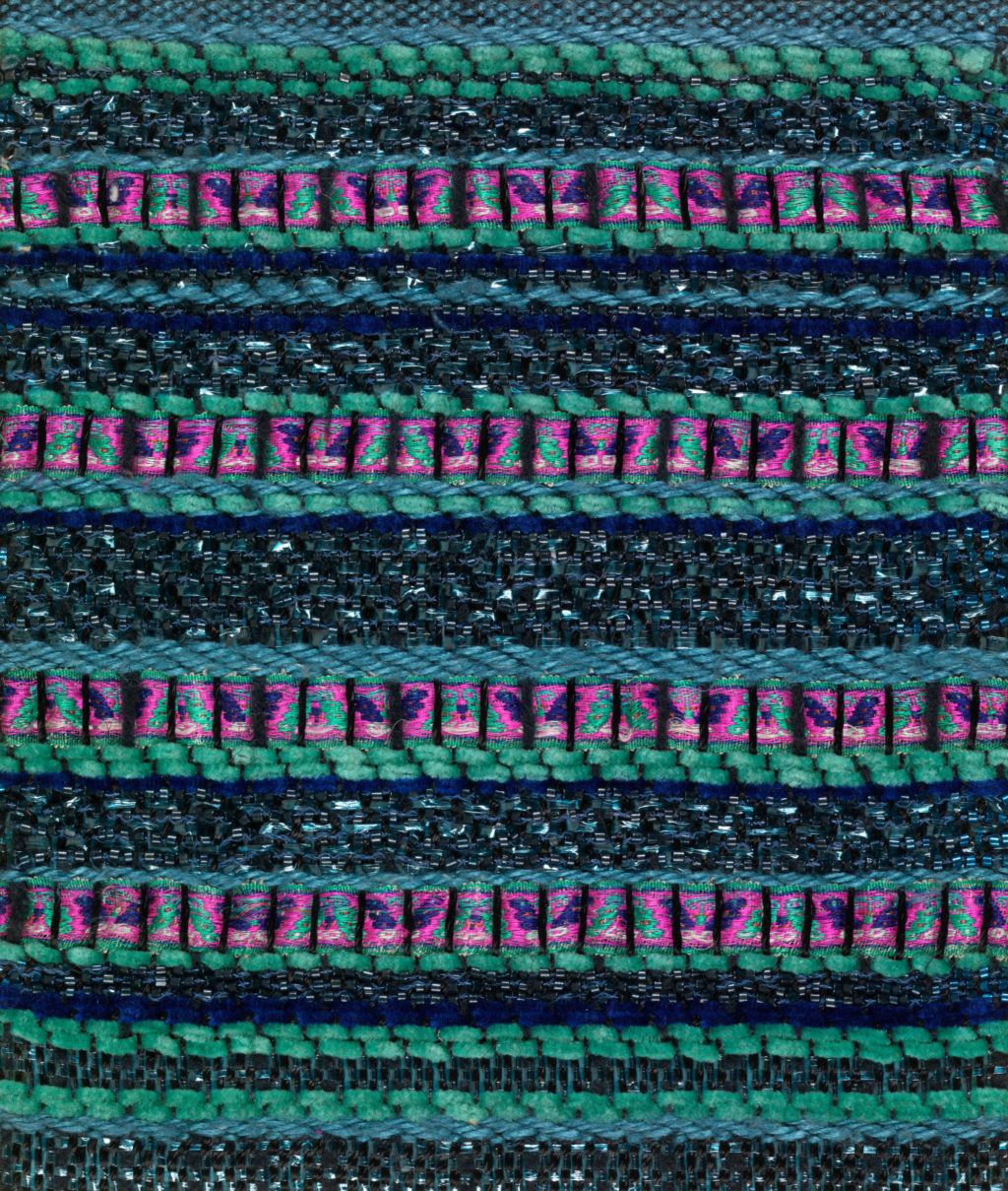 A close-up of textured, woven fabric in vibrant, glimmering blues and pinks.
