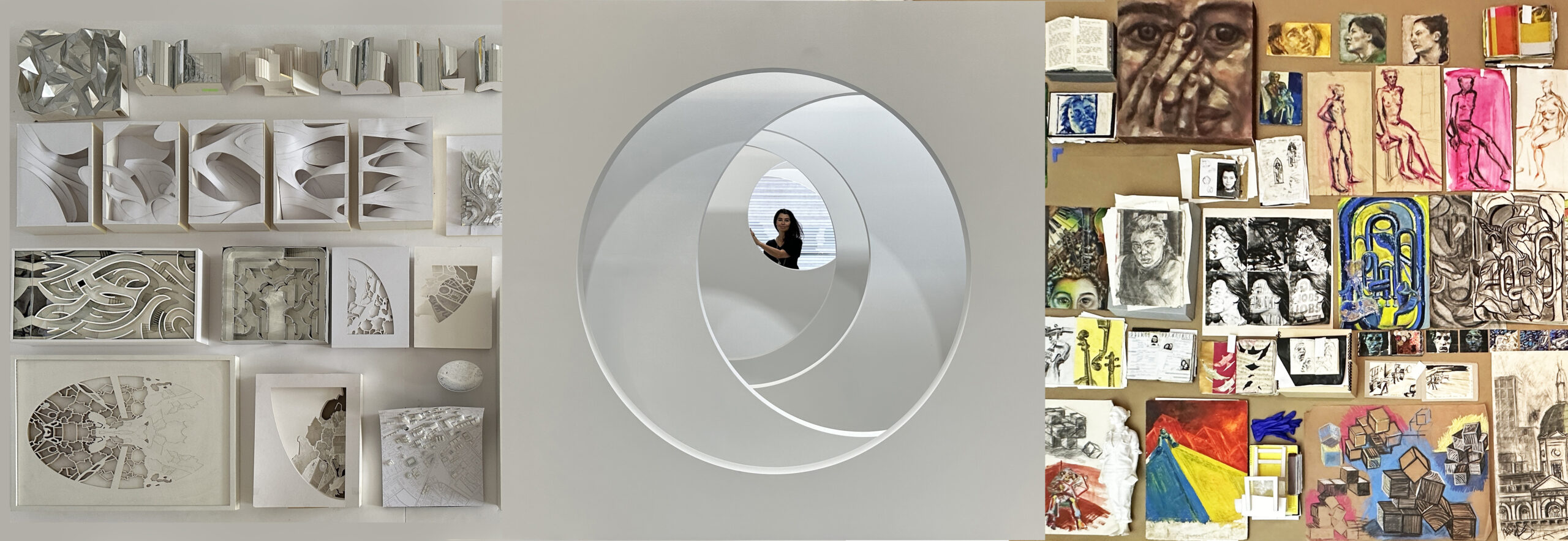 In the center is a large circle cut into a white wall. Es Devlin, a woman with dark hair, stands in the distance beyond this cutout, behind several overlapping crescent-moon-shaped layers of white. On the left, several curving 3D models and abstract drawings are arranged in a neat white and gray display. On the right is a vibrant, colorful collage of sketches and paintings.