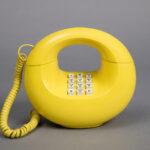 A banana-yellow corded phone with a receiver and base that connect in a donut-like loop.