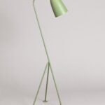An angular, light green floor lamp made of a couple of sleek metal poles and standing on three legs.