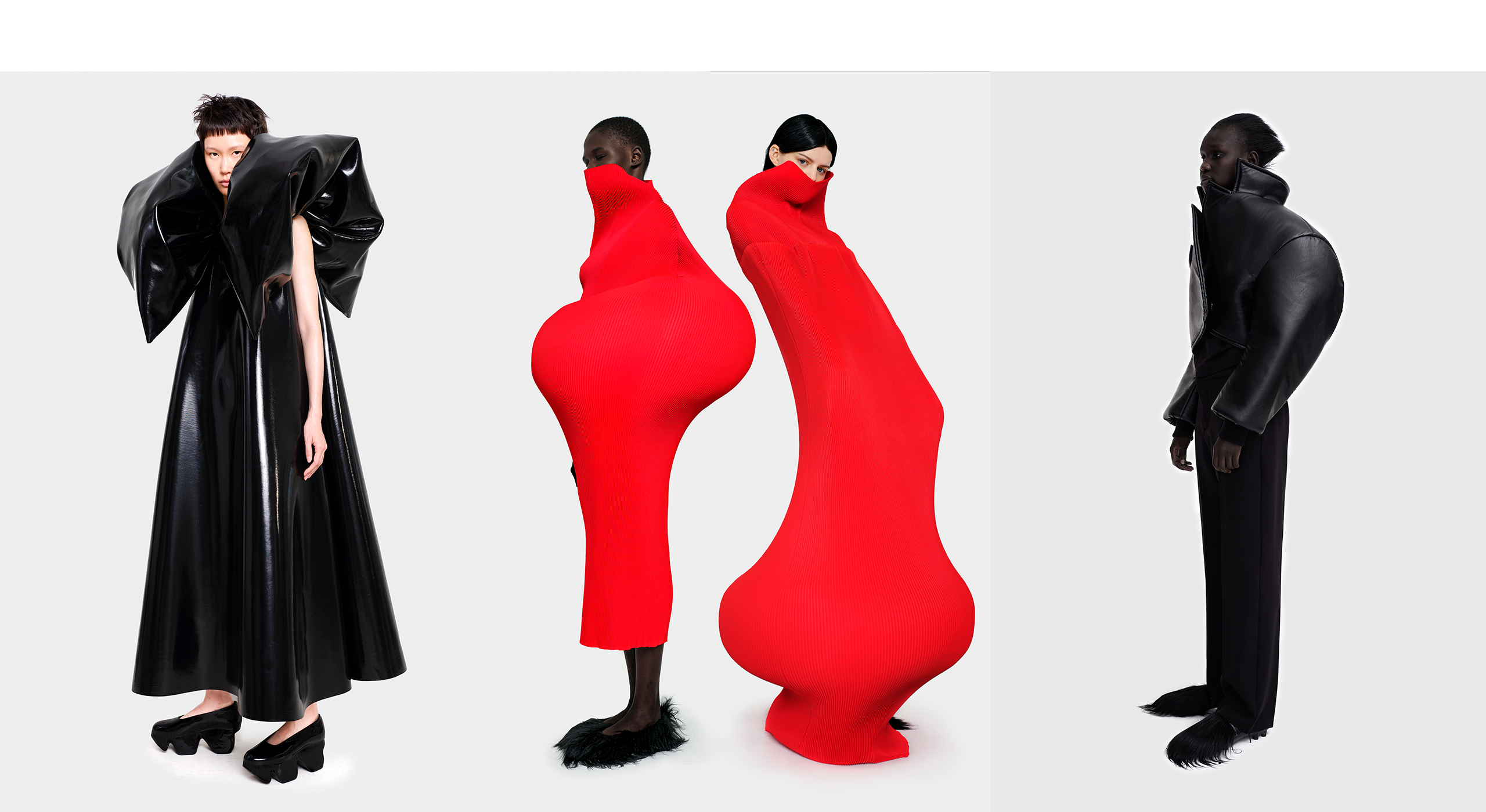 Three fashion designs by Melitta Baumeister. First image, person wearing black dress with large shoulders and black shoes; Second image, two people wearing red dresses with big round shapes; Third image, person wearing all black pants and shirt.
