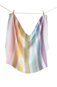 A white cloth striped with the colors of the rainbow hangs from a clothesline.