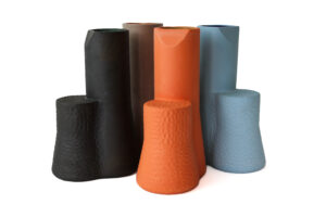 Five textured ceramic vases in muted black, brown, orange, and blue tones.