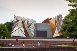 Outdoor pavillion with towering abstract mural panels.