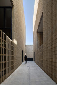 Outdoor passageway between two modern concrete buildings.
