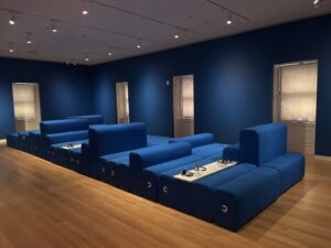 View of blue geometric seating area in a gallery with blue walls.