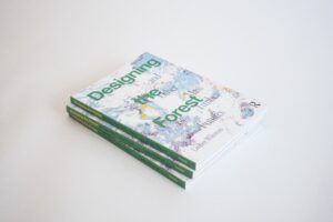 A stack of three identical books with green spines and muti-colored covers.