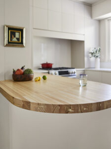 Section of kitchen counter made of polished wood with visible wood grain.