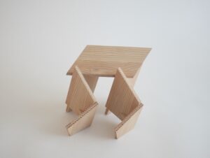 A model made of angular pieces of sanded wood assembled together at different angles to create an abstract take on a traditional pavillion.