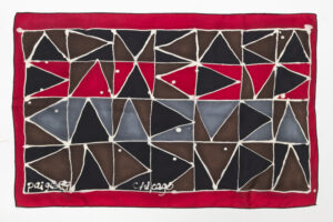 Geometric textile design featuring red, black, brown, and gray triangles outlined in white.