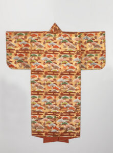 Golden yellow robe with long sleeves. A tree, leaf, and wooden fence pattern repeats in autumnal colors.