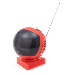 A red helmet shaped television with a square base with control knobs and an antenna at the top.