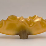 Golden metallic ombre sculpture shaped like antlers fanning upwards and outwards horizontally.