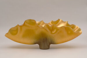 Golden metallic ombre sculpture shaped like antlers fanning upwards and outwards horizontally.