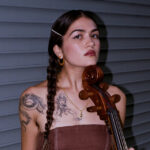 Portrait of person in brown dress with cello.